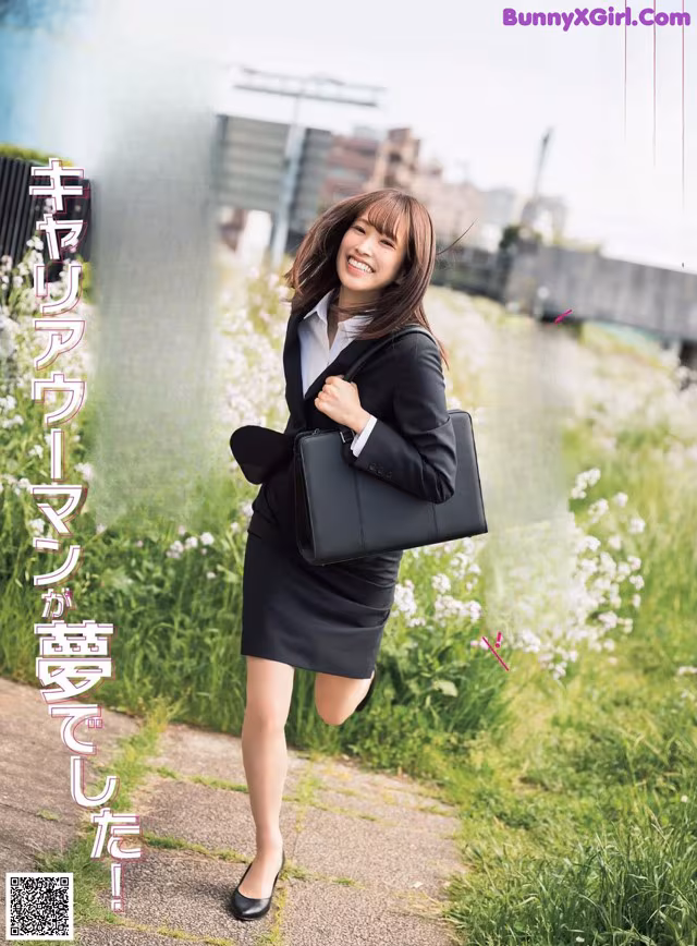 A woman in a business suit is walking down a sidewalk.