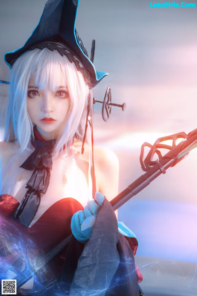 A woman dressed as a witch holding a sword.