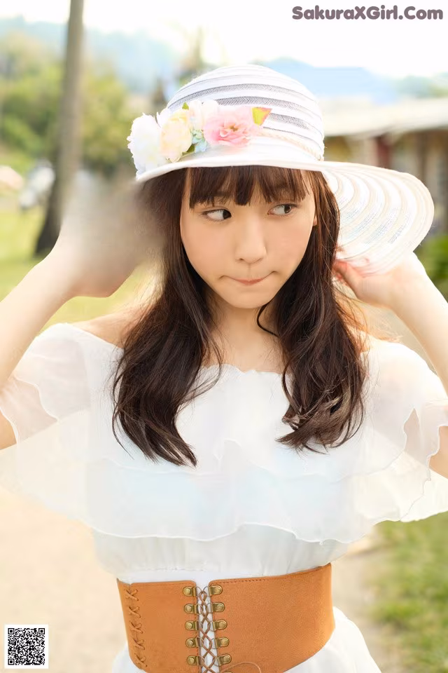 A woman wearing a white dress and a white hat.