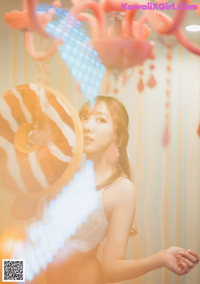 A woman in a white lingerie holding a large lollipop.