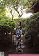 A woman in a kimono standing in a garden.