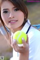 A woman holding a tennis ball in her hand.